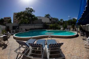 圣多明各雷纳瑟尔酒店的一个带两把椅子和一张桌子的游泳池