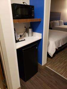 文特沃思港Holiday Inn Express & Suites - Savannah N - Port Wentworth, an IHG Hotel的一个小房间,配有电视和一张床
