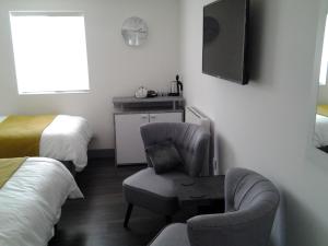 DowlaisLady Charlotte Guest rooms triple rooms的酒店客房设有椅子和电视。