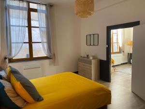 穆兰joli appartement quartier historique, 5 pers的一间卧室设有黄色的床和窗户。