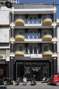 帕特雷Pietra Mare Suites的一座大型建筑,前面停有摩托车