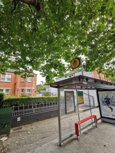 都柏林Baldara House的公园里一个公共汽车站,有红色长椅