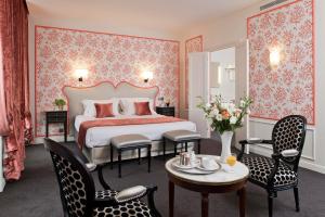 巴黎Hôtel Saint-Pétersbourg Opéra & Spa的卧室配有一张床和一张桌子及椅子