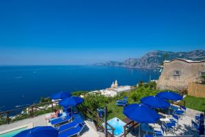 普莱伊亚诺Villa Il Frantoio and Lilmar的一组蓝色椅子和遮阳伞在水边