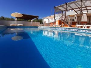 伊斯纳哈尔皮诺梭罗公寓的一个带遮阳伞的大型蓝色游泳池