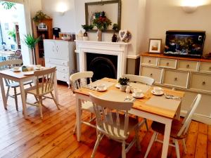 惠特利湾Sandsides Guest House的一间带桌椅和壁炉的用餐室