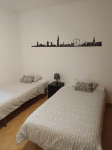 阿索马达Can Blum的卧室配有两张床,墙上设有架子。