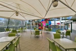 彭里斯悉尼彭里斯品质酒店的一间空置的餐厅,配有桌椅和游乐场
