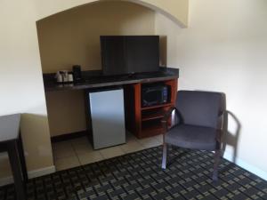 Lockbourne格伦布经济酒店的一间配有电视的房间和一张椅子