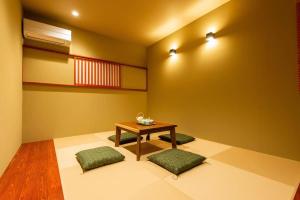 福冈SYA Hotel-上呉服町 一軒家貸し切り的配有桌子和两把绿色椅子的房间
