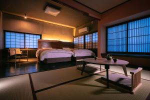 别府Yasuraginoyado Yufu的一间卧室配有两张床和一张桌子