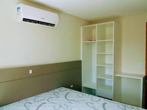 邦比尼亚斯Residencial Caminho das Praias的卧室配有床和空调。