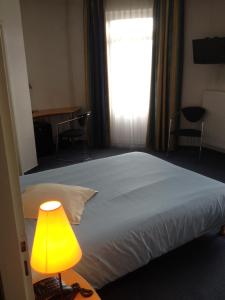 萨尔格米纳阿玛迪斯酒店的一间卧室配有一张带黄灯和窗户的床