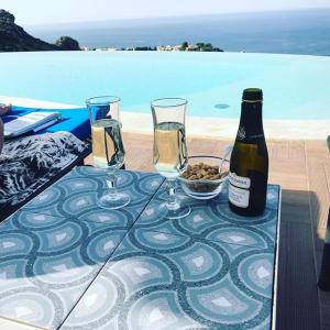 斯克佩罗Hotel Antica Cascina Del Golfo的一张桌子,上面放着两杯酒和一瓶葡萄酒