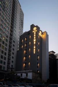 釜山Seomyeon Brown-dot hotel Gold的一座高大的建筑,旁边灯火通明