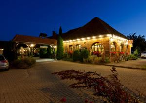 格赫伦-莱宾舒梅德乡村酒店的一座砖砌的建筑,晚上有灯