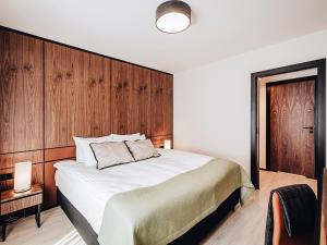 比得哥什Apartamenty Sowa Bydgoszcz的一间卧室配有一张带木墙的大床