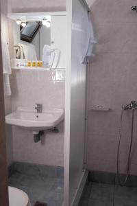亚历山德鲁波利斯克里奥酒店的白色的浴室设有水槽和淋浴。