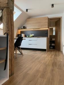 莫斯特拉纳18Home apartments, Mojstrana的阁楼厨房铺有木地板,配有书桌。