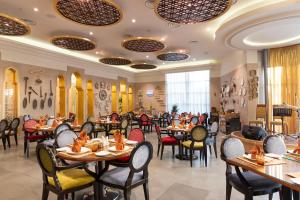 科威特Holiday Inn - Suites Kuwait Salmiya, an IHG Hotel的一间在房间内配有桌椅的餐厅