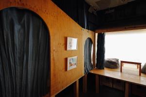 高松晴天旅舍的一间设有黑色窗帘和木墙的房间