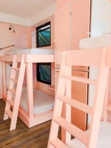查汶苏梅岛场景俱乐部酒店的粉红色的双层床间,配有梯子和双层床