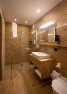 巴特马林贝格Steig-Alm Hotel Superior的一间带水槽、淋浴和卫生间的浴室