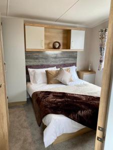 赫尔斯顿The Lizard Bluewater的一间卧室配有一张大床和木制床头板