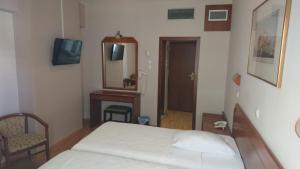 雅典经济酒店的一间卧室配有一张床、梳妆台和镜子