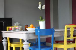 斯普里蒙Liotte'sCorner Guesthouse的一张桌子,有四把椅子和一碗橙子