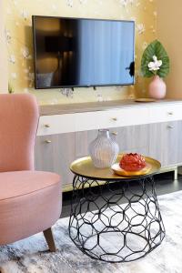 萨尔瓦尔Club Luxury Apartman的客厅配有电视、桌子和椅子