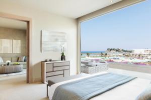 撒尼海滩Sani Dunes的一间卧室配有一张床,享有海滩美景