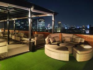雅加达Erian Hotel的一个带椅子的屋顶庭院,享有城市美景