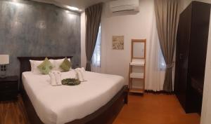 查龙Cocoville Phuket - SHA Plus的一间卧室配有一张带白色床单的大床