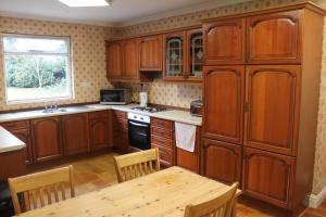 鲍尔多克Brookside Lodge的厨房配有木制橱柜和木桌。