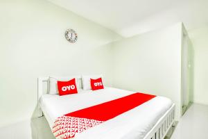 坤西育府OYO 722 I Oun Inn的白色卧室配有白色的床和红色枕头