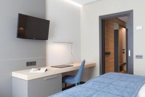 马德里里阿本酒店的一间卧室配有书桌、一张床和电视。