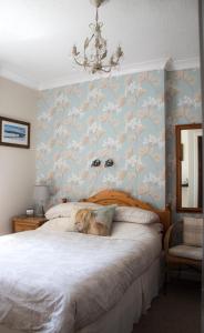 爱丁堡Whitecroft B&B的一间卧室配有一张带花卉壁纸的床