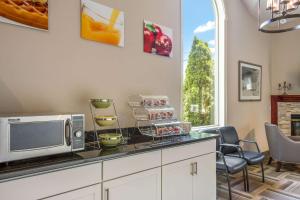 戈勒姆Quality Inn & Suites的厨房配有带微波炉和椅子的柜台