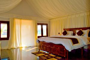 BeraThour Nature Resort - Jawai Leopard Safari Camp的一间卧室配有一张带天蓬的大床