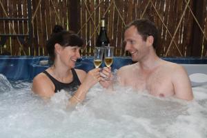 马特洛克凯博斯旅馆的男人和女人在带酒杯的热水浴缸中
