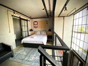 卢萨卡The Cubes的带阳台的客房里设有一间带一张床的卧室