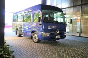 福冈Hotel Trad Hakata的停在大楼前的一辆蓝色巴士