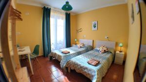 希洪Hostel GoodHouse Gijón的一间卧室设有两张床、一张桌子和一个窗口。