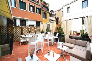 威尼斯丰塔纳酒店的阳台的庭院配有白色的桌椅