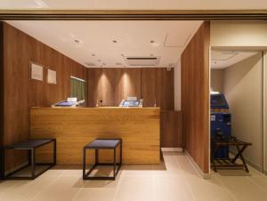 东京横丁品川青物超级酒店的一间设有两张凳子和柜台的等候室