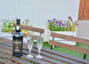 加亚新城Porto Garden Villas | Downtown的木凳上的一瓶葡萄酒和两杯酒