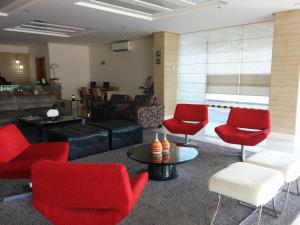 圣路易斯Stop Way Hotel São Luís的客厅配有红色椅子和沙发