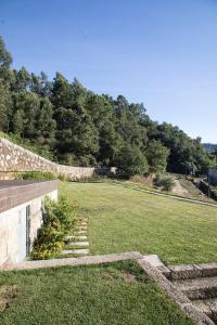 圣托·蒂尔索Quinta da Casa Nova的一块带石墙和楼梯的大型草地