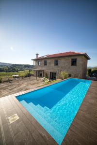 圣托·蒂尔索Quinta da Casa Nova的一座大蓝色游泳池,位于房子前